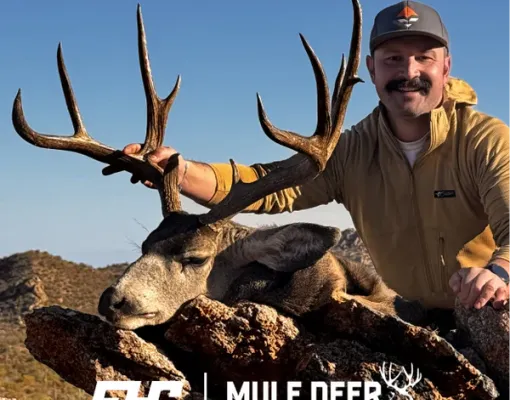 Hunter posing with harvested mule deer