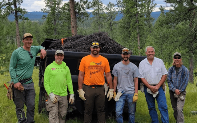 Group photo of volunteers engaged in conservation work in a forested area.